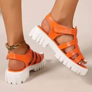 Detailed side view of orange gladiator platform sandals with white chunky sole