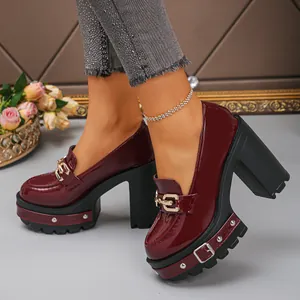 Nahaufnahme von burgunderroten Plateau-Loafers aus Lackleder mit Blockabsatz und Nieten.