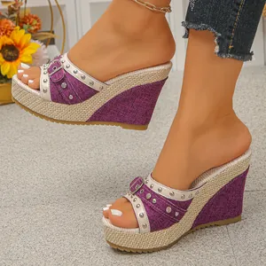Détail de sandales à talons compensés en denim violet avec brides cloutées et paille