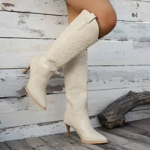 Détail de bottes de cowboy western brodées blanc cassé avec talon aiguille et bout pointu.