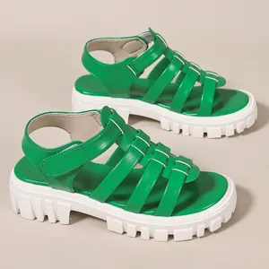 Detailed side view of green breathable Roman sandals with white platform soles.