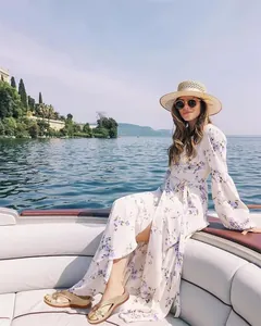 Modelo luciendo sandalias de plataforma con flores durante un paseo en bote por un hermoso lago