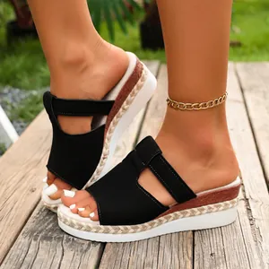 Detail shot of black wedge platform sandals with woven jute and wood texture heel.