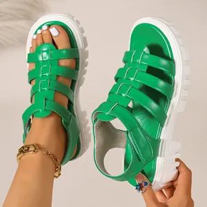 Detail of vibrant green Roman sandals with thick white platform soles for summer.