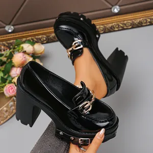 Detailaufnahme von schwarzen Gothic-Plateau-Loafers mit goldener Kette und Nieten