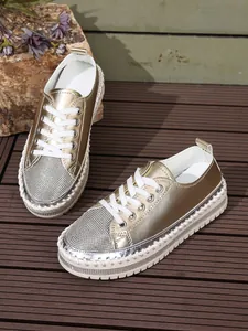 Fashion platform sneakers with gold metallic finish and sparkling rhinestone details