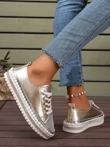 Close-up of fashion metallic silver platform sneakers with rhinestone detail and laces.