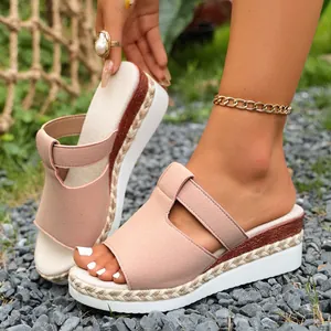 Detail of pink suede wedge platform slides with braided jute texture and white sole.