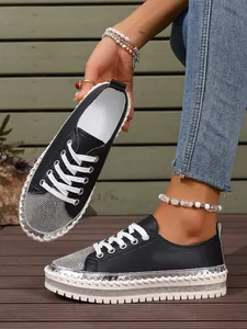 Stylish black platform sneakers with shimmering rhinestone toe and metallic whipstitch detail.