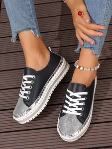 Stylish black platform sneakers for women featuring sparkling rhinestone toes and thick white soles