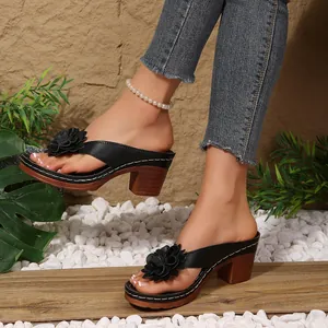 Elegant black platform wedge sandals featuring decorative floral design and wood-grain heels