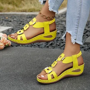 Stylish bright yellow wedge sandals with decorative metal buckles and elastic straps