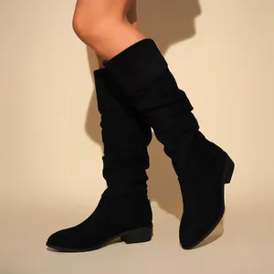 Side view of black suede slouchy knee-high boots with mid block heels and pointed toes