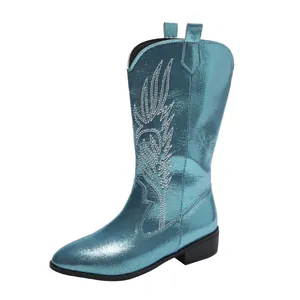 Detail view of a metallic turquoise cowboy boot with white wing embroidery and pointed toe.