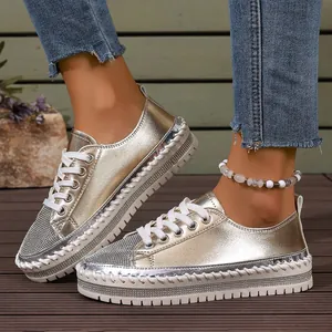 Stylish women's metallic gold platform sneakers with rhinestone accents and laces.