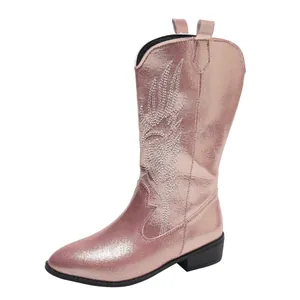 Detailed view of metallic rose gold cowboy boot with intricate white embroidery patterns