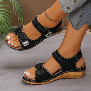 Detailansicht der schwarzen Keilsandalen im römischen Stil mit Peep-Toe-Design am Fuß