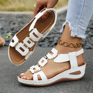 Close-up detail of stylish white wedge sandals with gold metal buckles and comfort straps