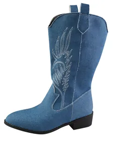 Detailed view of the blue denim cowboy boot featuring intricate white wing embroidery.