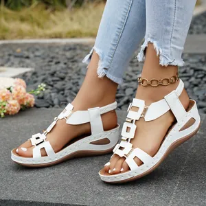 Close-up of white women's platform wedge sandals with gold metal buckle details