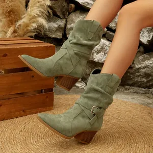 Detailed view of olive green suede slouchy western boots featuring decorative buckle strap