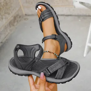 Detalle de sandalias deportivas grises para mujer con correas ajustables y suela blanda