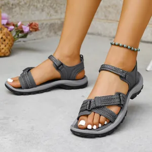 Primer plano de sandalias deportivas grises para mujer con suela blanda