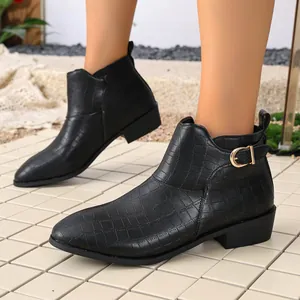 Side view detail of black crocodile embossed leather ankle boots with gold buckle