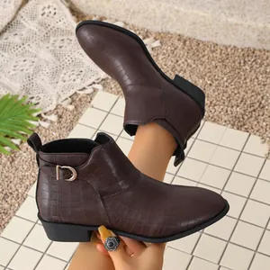 Detailed view of women's dark brown crocodile pattern ankle boots with elegant metal buckle