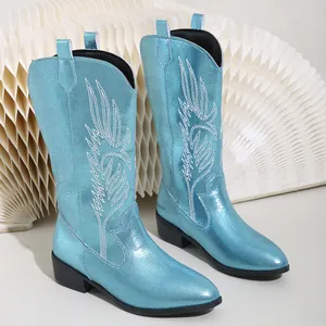 Detailed view of the metallic blue surface and intricate white embroidery on the cowboy boots