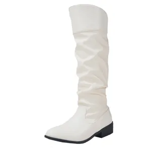 Side view of white pointed toe slouchy knee-high boots with low block heel.
