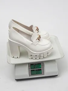 Weiße Plateau-Loafer aus Lackleder mit 11-cm-Absatz auf einer Waage präsentiert