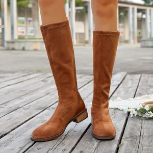 Detailed view of tan suede knee-high boots with square toe and low heel design.