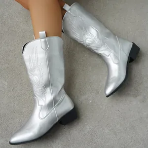 Detailed view of silver embroidered cowboy boots with pointed toe and square heel