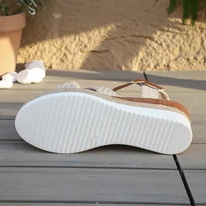 Detailopname van de witte antislipzool van de modieuze dames-sandalen met sleehak