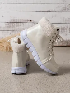 Detailopname van gebroken witte winterlaarzen met parelglans en rand van imitatiebont.
