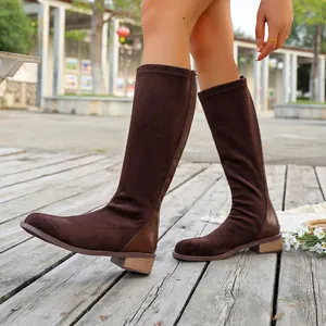 Side profile of brown suede knee-high boots with square toe and low block heel.