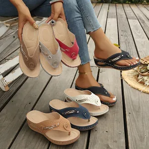 Vista detallada de sandalias de cuña en varios colores sobre una plataforma de madera