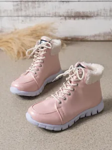 Detailopname van roze dames winterlaarzen met witte fleece rand en dikke plateauzool