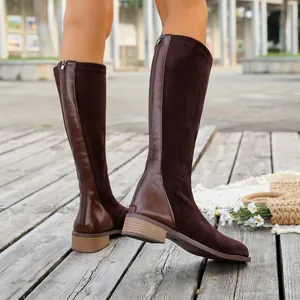Dark brown suede knee-high boots with back zipper and square toe on wooden deck