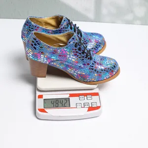 Detailed view of colorful lace-up chunky heel pumps on a scale showing lightweight design