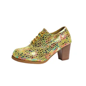 Detailed side view of fashionable yellow lace-up chunky heel pump with colorful dots