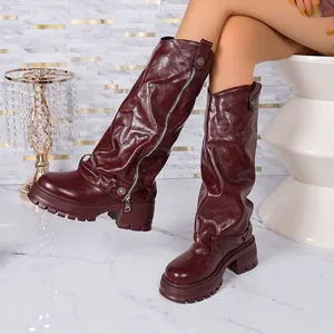 Detailed view of burgundy slouchy platform knee-high boots with stylish side zipper