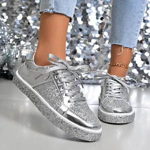 Close-up of silver sequin platform sneakers with metallic laces and disco ball background.
