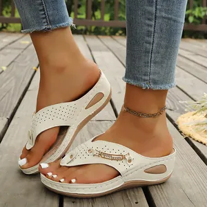 Detailweergave van crème sleehak-slippers met strass-gesp en lasergesneden patronen.