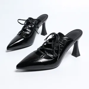 Detailansicht von schwarzen, spitzen High Heels zum Schnüren mit ausgestelltem Blockabsatz.