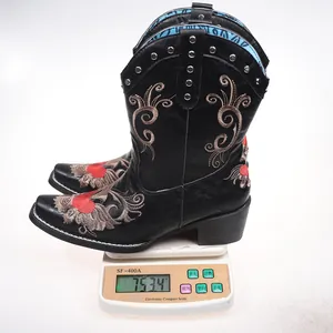 Detailed view of embroidered cowboy boot weighing 753.4g on an electronic scale