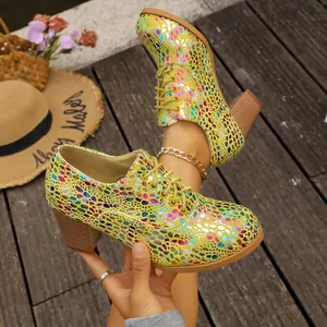 Detailed view of yellow lace-up chunky heels with vibrant metallic spotted patterns
