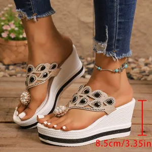 Detalle de la altura del tacón de cuña de 8,5 cm de las sandalias de plataforma.