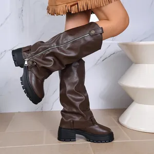 Detailed view of brown slouchy platform knee-high boots with side zipper and lug sole